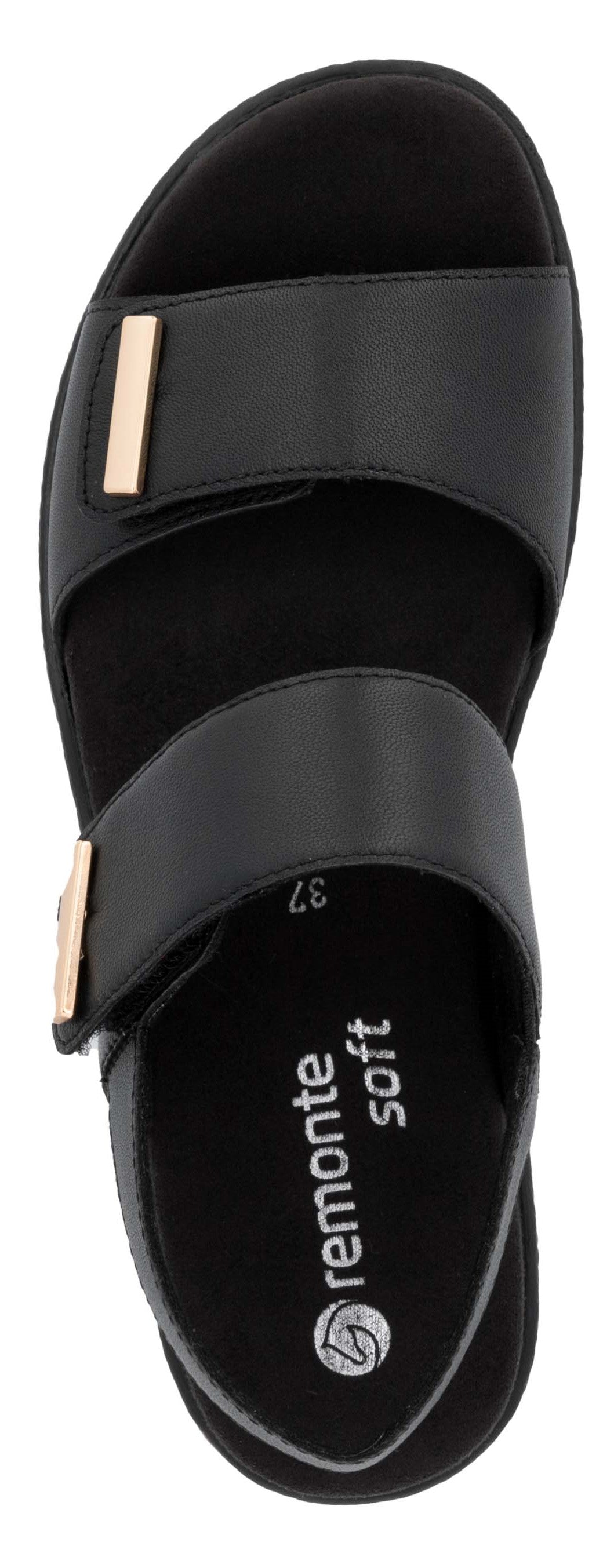 A black sandal with two straps and a gold buckle.