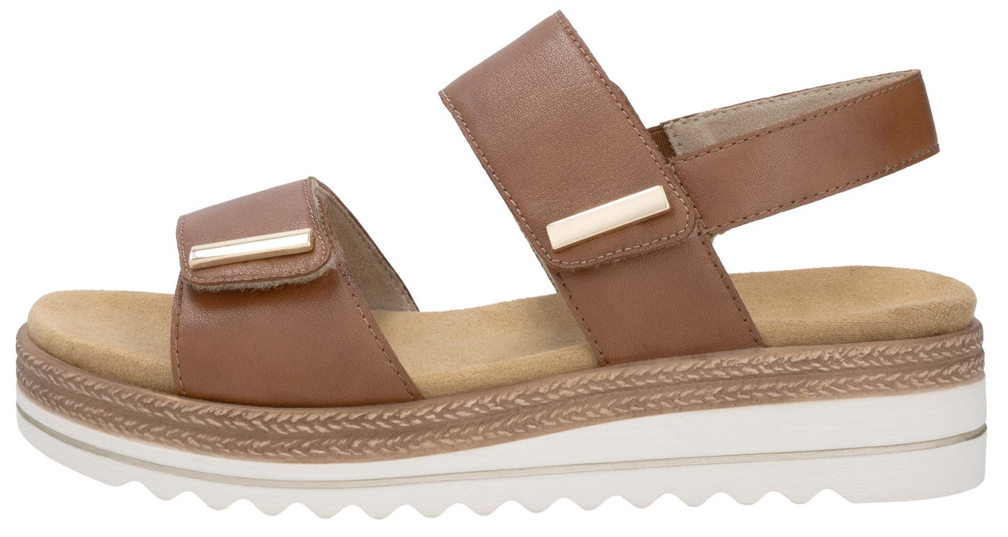 Tan sandal with platform sole and adjustable hook and loop straps.