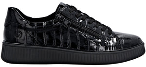 A black sneaker made of patent leather with a textured, crocodile-skin pattern, featuring black laces and a functional side zipper, set upon a solid black ridged rubber sole.