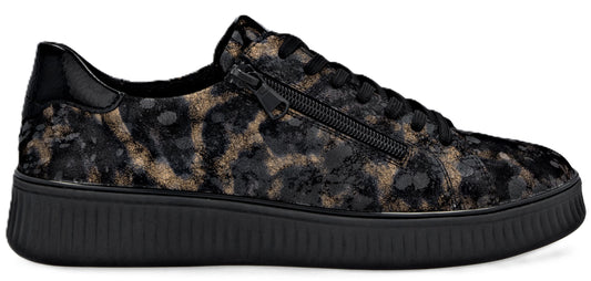 A close-up of an animal print low top sneaker with a black sole and a black zipper.