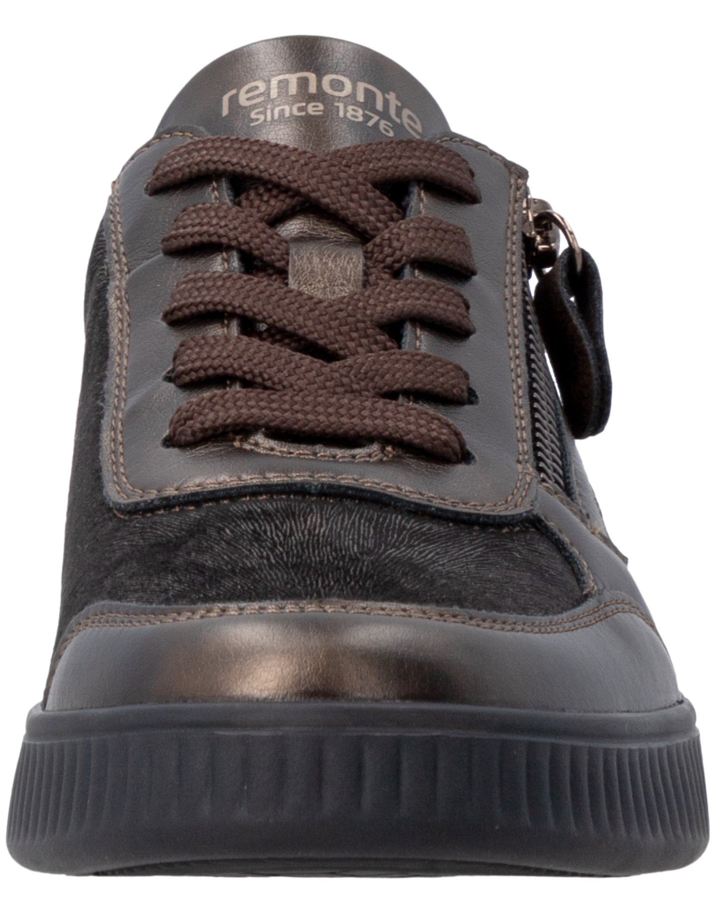 A close-up front view of a dark brown sneaker with a metallic finish toe cap, brown laces, a side zipper, and a black ridged rubber sole, featuring the word remonte Since 1876 printed on the tongue.