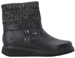 A black leather ankle boot with a grey knit cuff, a side strap with two silver buttons, and a thick black rubber sole.