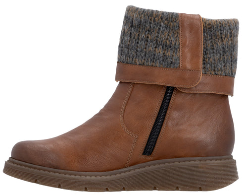 A tan faux-leather ankle boot with a charcoal grey knit cuff, a side zipper, and a low, textured rubber sole.