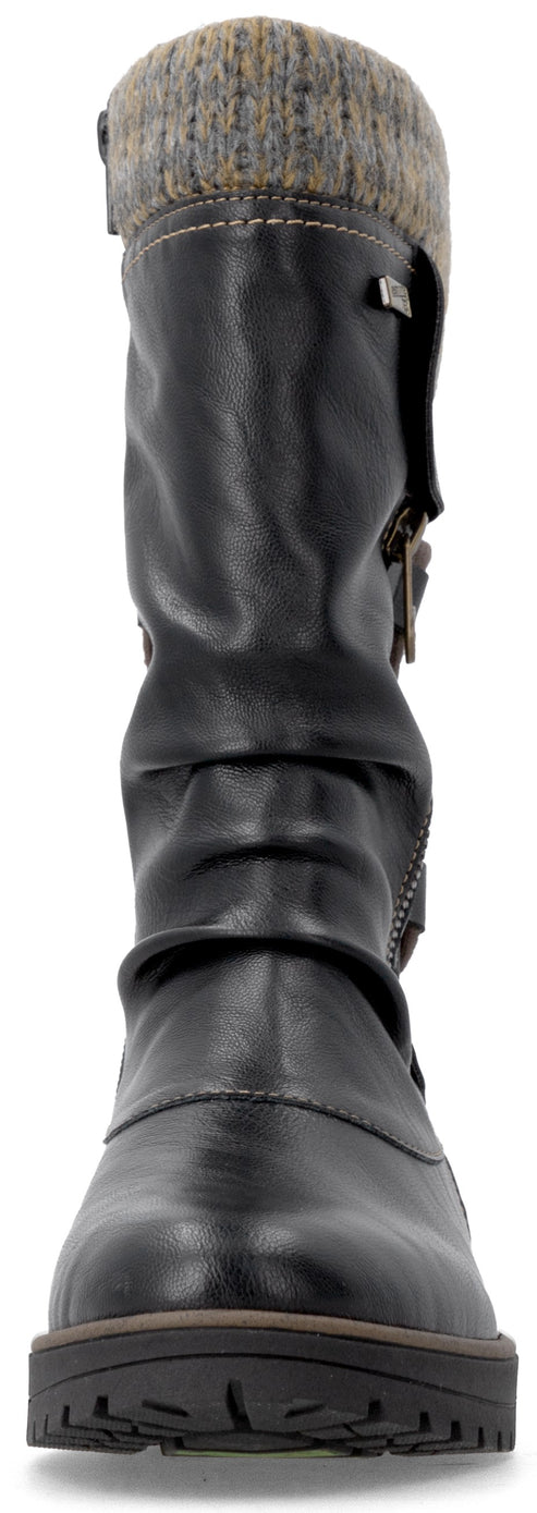A black mid-calf boot with a textured, multi-colored knit cuff at the top, featuring a slouchy synthetic leather shaft, a side zipper, and a thick, dark rubber sole.