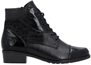 A black ankle boot with a lace-up front, a round toe, and a low block heel, featuring a mix of matte and patent leather textures with an embossed lace pattern on the side panel.