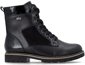 A black leather and suede lace-up boot with a patent leather collar and heel, featuring metal eyelets, a lugged sole, and a Rieker Tex logo tag on the side.