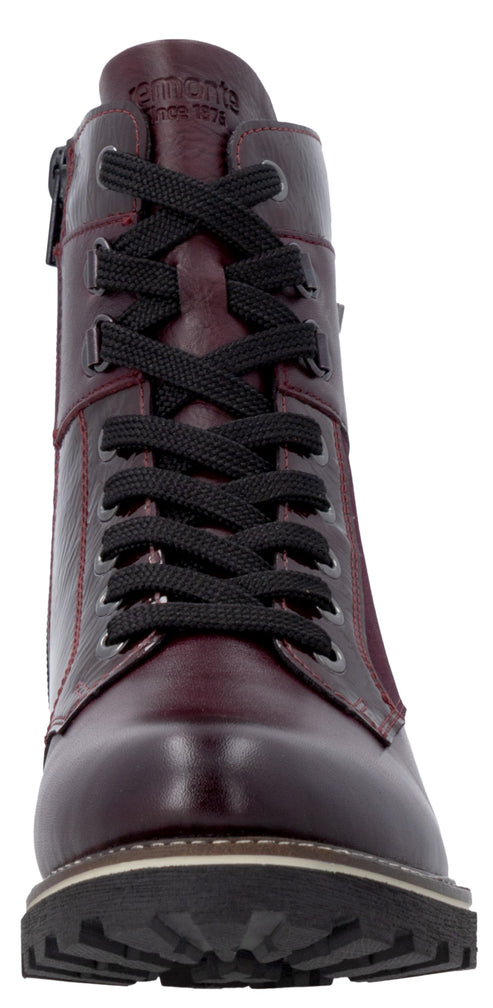 A front view of a deep burgundy leather lace-up ankle boot with a black lug sole and a small brand logo embossed at the top of the tongue.
