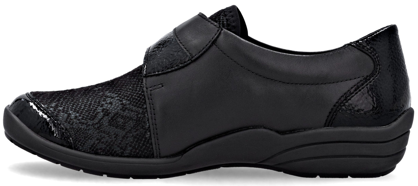 A black slip-on comfort shoe for women, featuring a smooth faux leather mid-section, a textured pattern on the rounded toe and heel, and a thick, dark rubber sole.