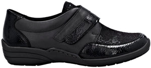A black orthopedic shoe with a textured, snakeskin-like pattern on the heel, toe, and velcro strap, featuring a smooth side panel and a thick, dark gray sole.