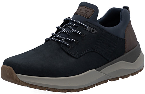 A dark blue men's sneaker with a brown leather tongue patch and heel panel, featuring a thick gray midsole and a brown lugged outsole, shown from a side-angle view.