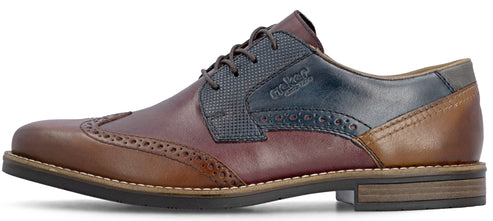 A men's lace-up wingtip oxford dress shoe featuring a multi-tone leather design with brown, deep red, and dark blue textured panels, brogue detailing, and a low stacked heel.