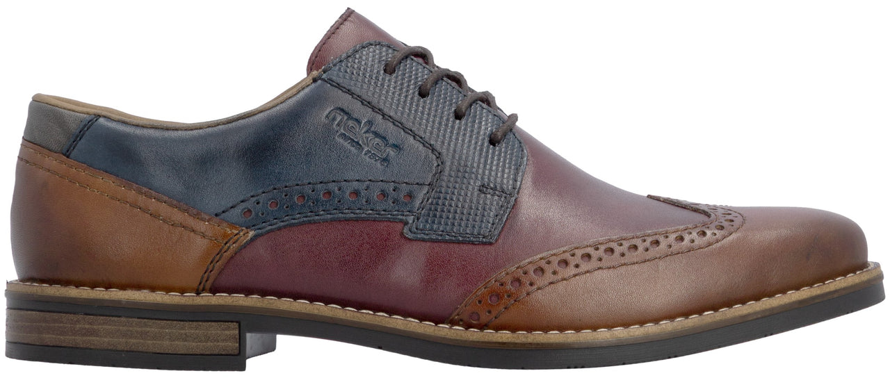 A men's lace-up oxford shoe with a multi-toned leather design featuring tan at the heel and toe, burgundy leather on the quarter, and a textured navy blue panel with the etched logo text across the lace eyelets, finished with decorative broguing along the seams and a stacked dark sole.
