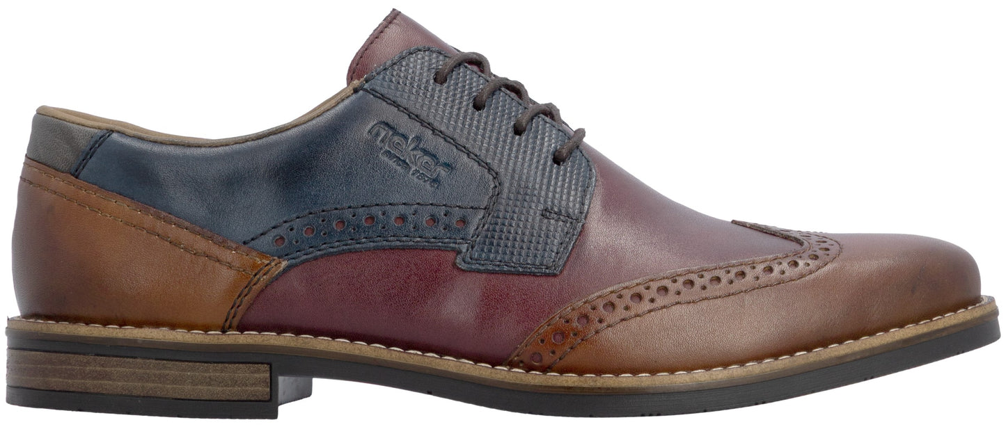 A men's lace-up oxford shoe with a multi-toned leather design featuring tan at the heel and toe, burgundy leather on the quarter, and a textured navy blue panel with the etched logo text across the lace eyelets, finished with decorative broguing along the seams and a stacked dark sole.
