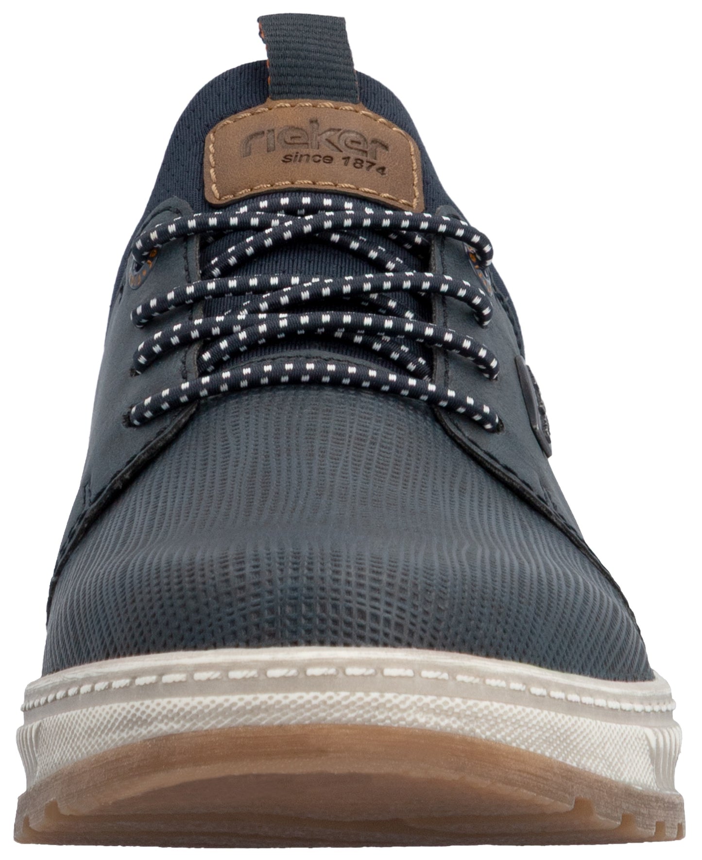A low-angle front view of a dark navy blue casual men's sneaker featuring a textured synthetic upper, a brown leather-like tongue patch with the text 'rieker since 1874', speckled black-and-white laces, and a thick, ridged white midsole with a gum-colored rubber outsole.