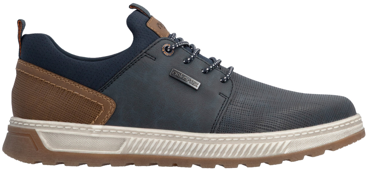 A low-top sneaker with a dark blue navy upper, brown textured heel panel, and a white ridged midsole with a brown treaded outsole. It features navy laces, a padded navy collar, and a small dark rectangular branded tag on the lateral side.