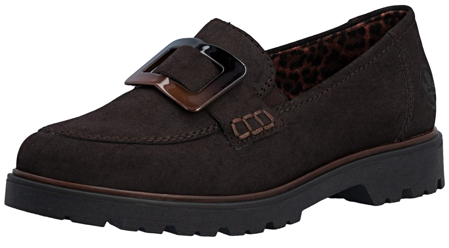 A dark brown suede loafer with a chunky, dark brown tortoise-shell buckle on the front, thick black lug sole, and leopard-print interior lining.