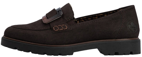 A brown suede slip-on loafer with a thick lug sole, featuring a decorative buckle strap across the instep and visible stitching detail on the side.