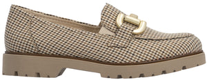 A tan and dark brown houndstooth-patterned loafer shoe featuring a thick, beige lug sole and a large, gold-toned metal bar ornament on the top.