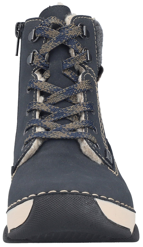 A close-up, front-facing view of a dark navy blue, mid-calf, lace-up winter boot. The boot features a textured dark blue and light gray lace, a light-colored faux fur lining, thick cream-colored contrast stitching around the base, a black rubber sole, and a silver side zipper.