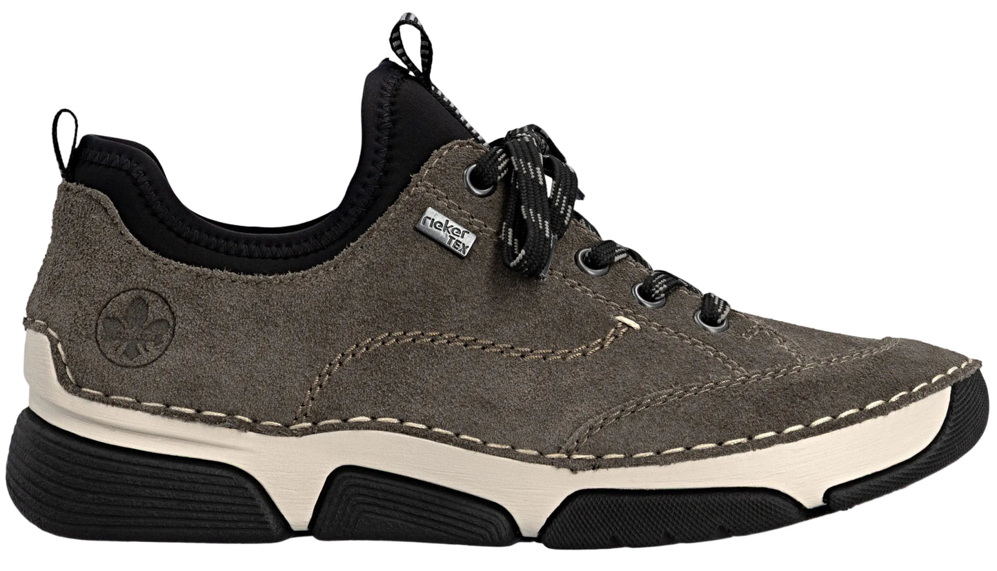 A gray suede Rieker brand sneaker with a thick, cream-colored midsole and a black rubber outsole. It features black laces, a black elastic ankle collar, a pull tab at the back, and the Rieker logo embossed on the side.