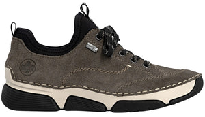 A gray suede Rieker brand sneaker with a thick, cream-colored midsole and a black rubber outsole. It features black laces, a black elastic ankle collar, a pull tab at the back, and the Rieker logo embossed on the side.