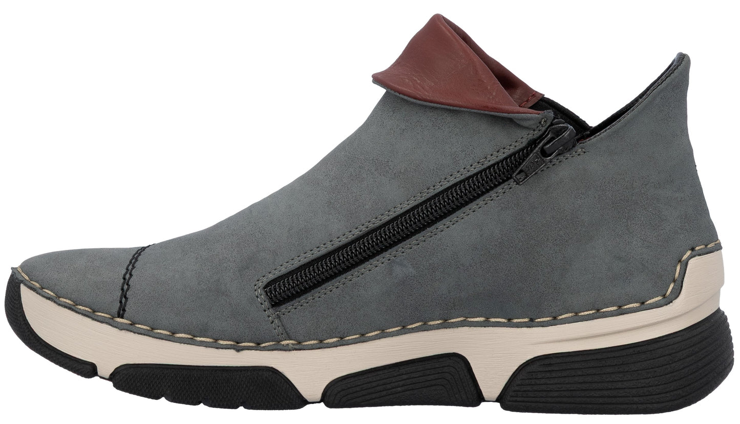 A slate gray slip-on shoe with a folded brown collar, side zipper detail, off-white midsole, and a black treaded outsole.