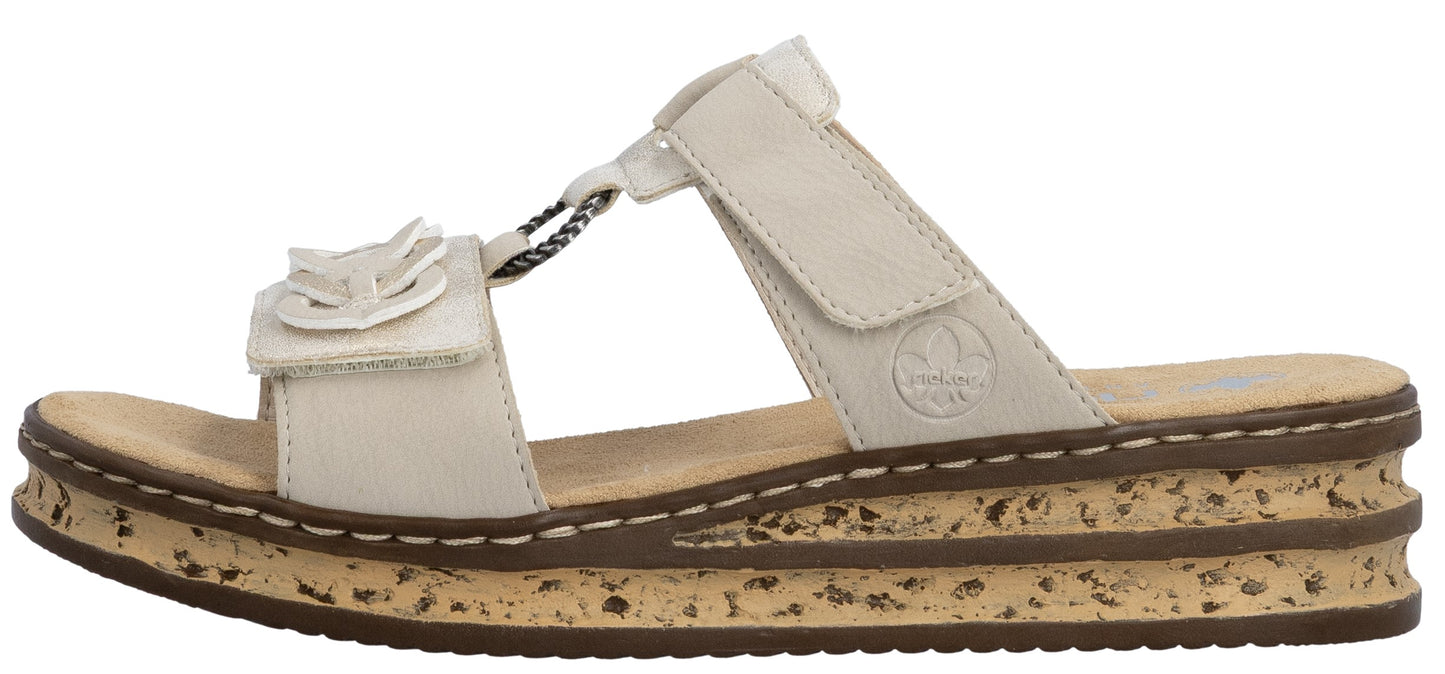 A beige slide sandal with a flower accent and cork platform.