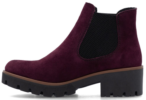 A lug heeled Chelsea boot made of purple suede with black goring.
