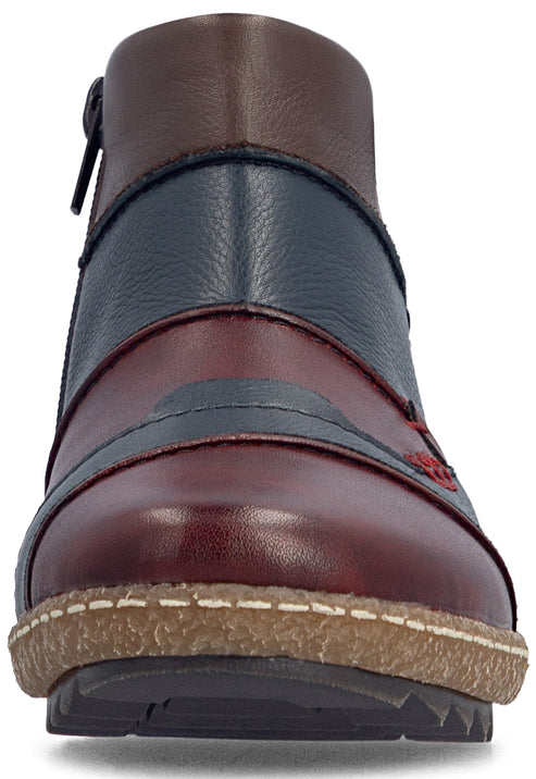 Front view of a multi-colored leather ankle boot featuring a brown ankle panel, navy blue mid-section, and a deep red toe cap with grey accents and red stitching, set on a beige textured sole.