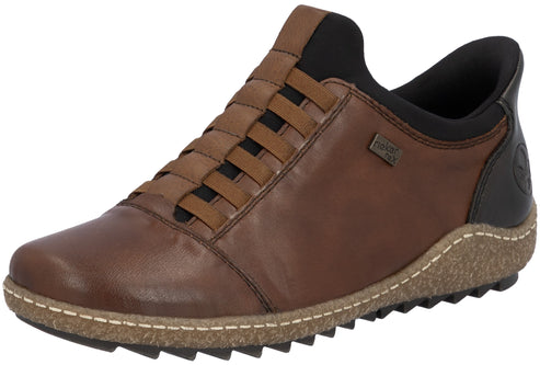 A brown leather slip-on shoe with a black collar and heel patch, featuring brown horizontal elastic straps over the instep, a speckled cork-like midsole with visible white stitching, and a black serrated rubber outsole.