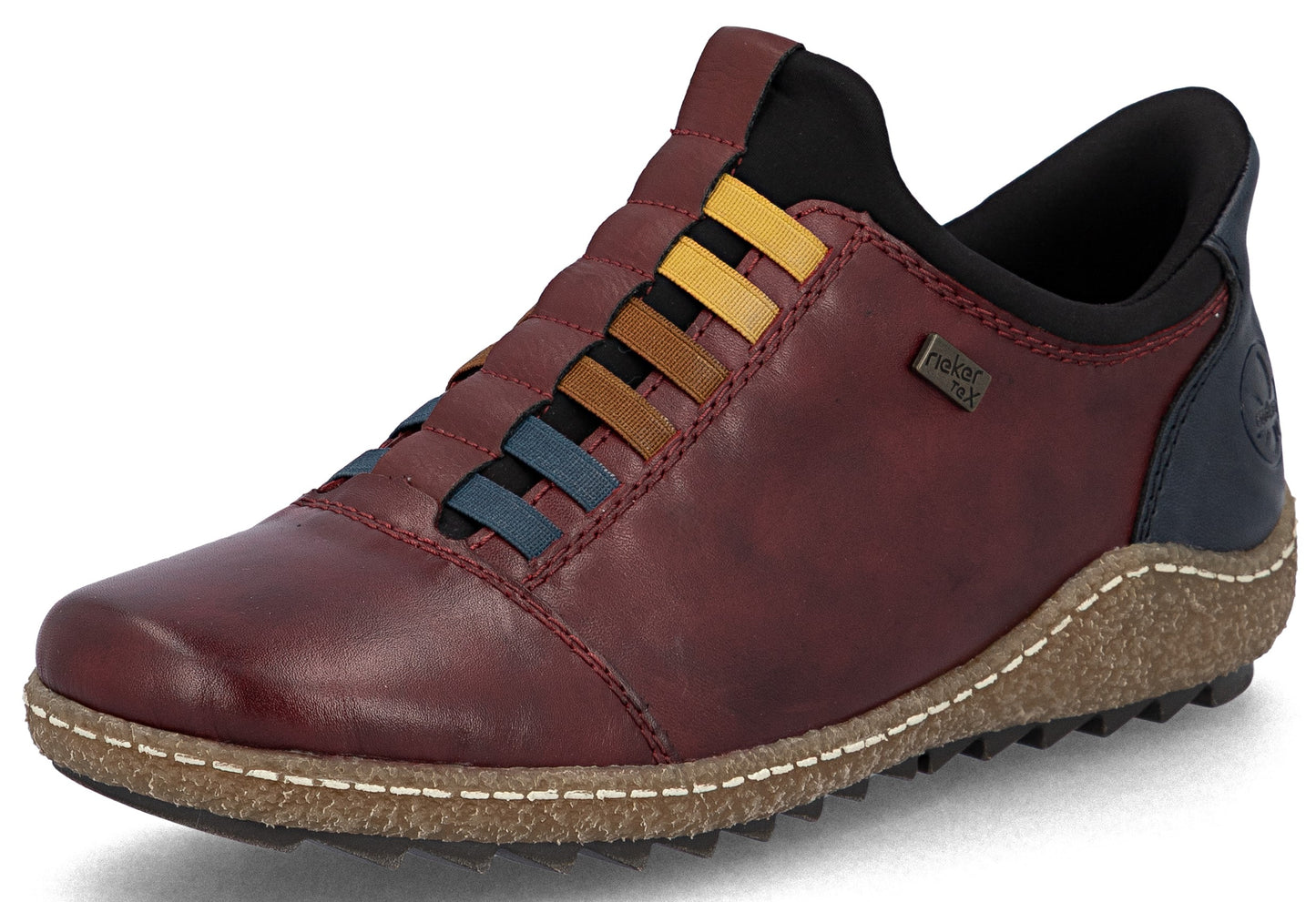 A slip-on shoe in deep red leather, featuring decorative laces in shades of blue, brown, and yellow, a dark blue heel, and a textured, cork-like midsole with white stitching, viewed from a side angle.