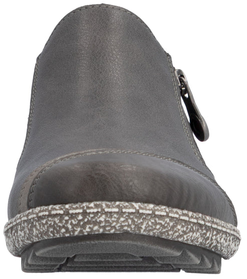 A close-up, front-facing view of a dark grey leather ankle boot, featuring a rounded, slightly pointed toe, a distinct thick, textured, grey-and-white speckled midsole, and a visible zipper pull on the side.