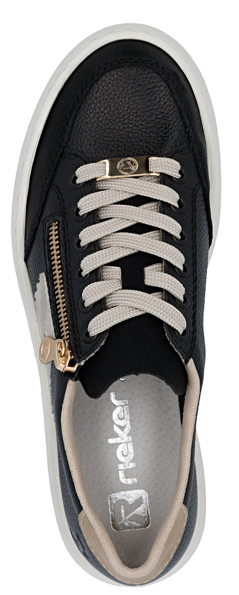 A close-up of a black sneaker with a gold zipper and white laces.