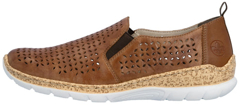 A tan-colored slip-on shoe with decorative cutouts, a cork-textured midsole, and a white sole.
