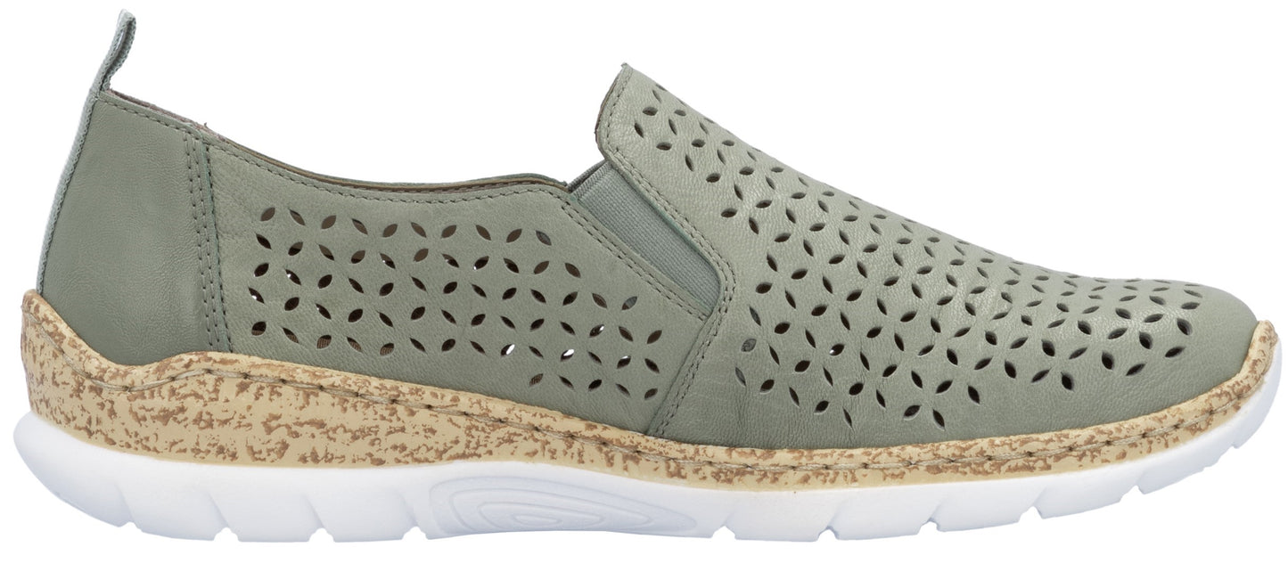 A sage-green slip-on shoe with decorative perforations, a cork midsole, and a white outsole.