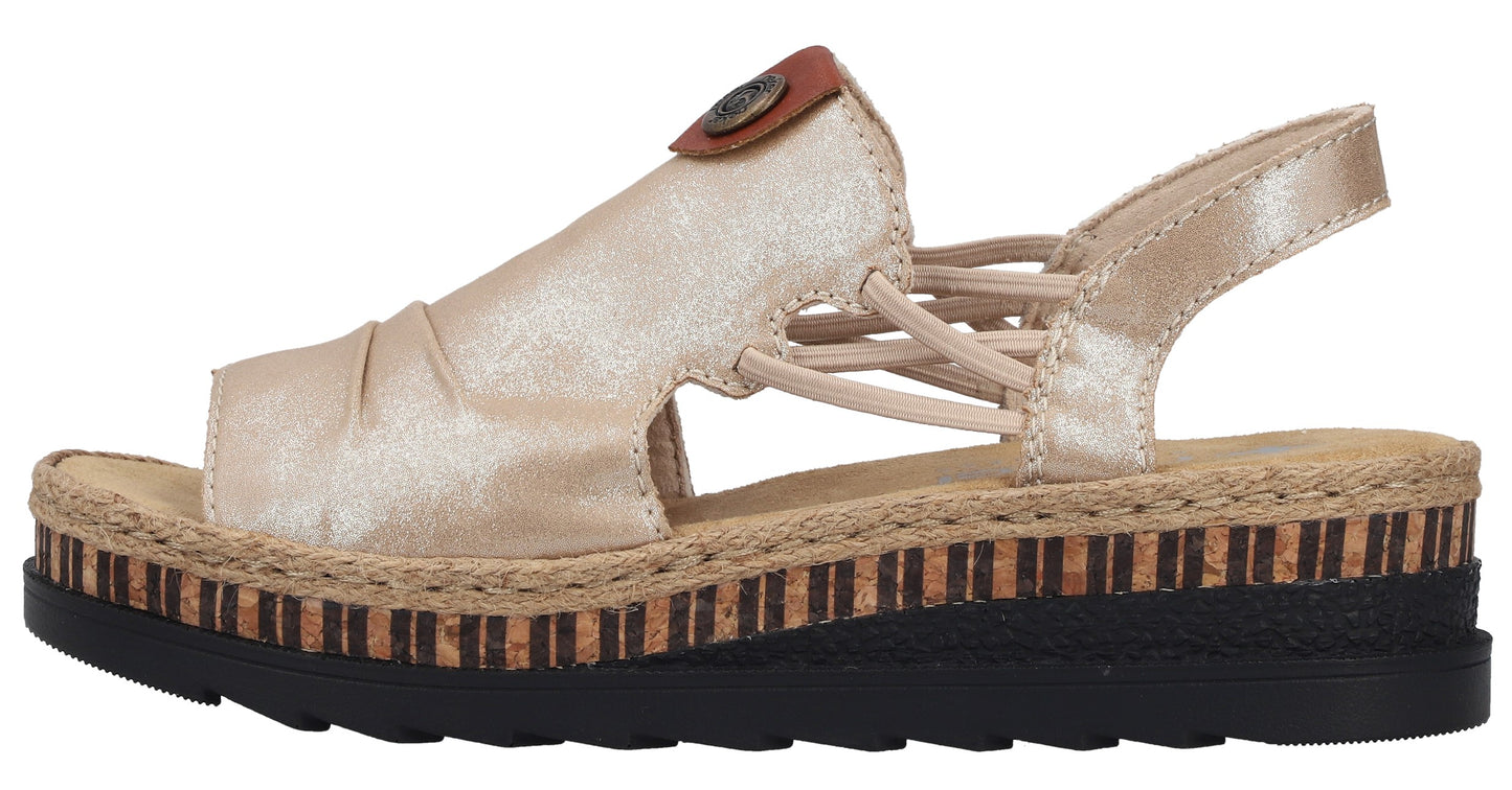 Gold sandal with a low platform heel, open toe, decorative elastic straps, and button accent.