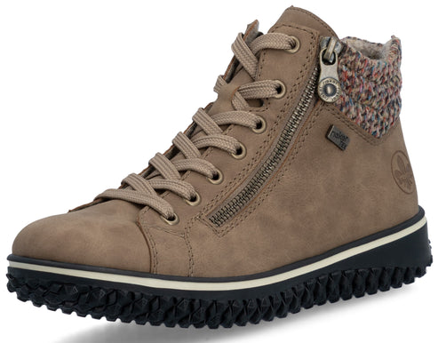 A tan ankle-height sneaker boot featuring a textured black lug sole, a lace-up front, a side zipper, and a colorful knit cuff at the collar with a small Rieker Tex logo visible on the side.
