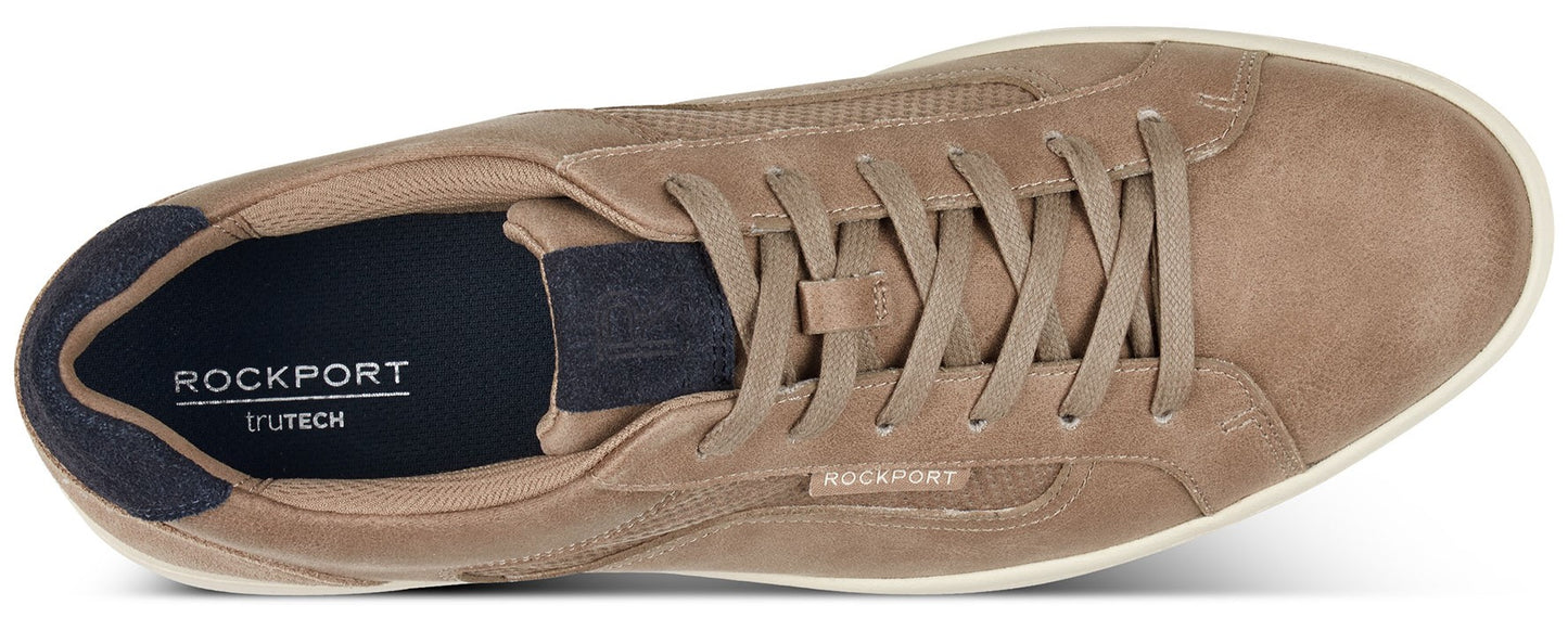 A tan suede low-top sneaker with white soles and laces, featuring the ROCKPORT logo at the heel.