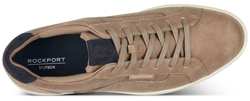 A tan suede low-top sneaker with white soles and laces, featuring the ROCKPORT logo at the heel.