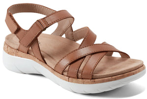 Tan sandal with criss-cross straps and a white sole.