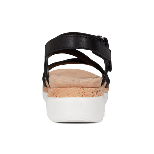 Rear view of a black sandal with a cork-look midsole and a white outsole.