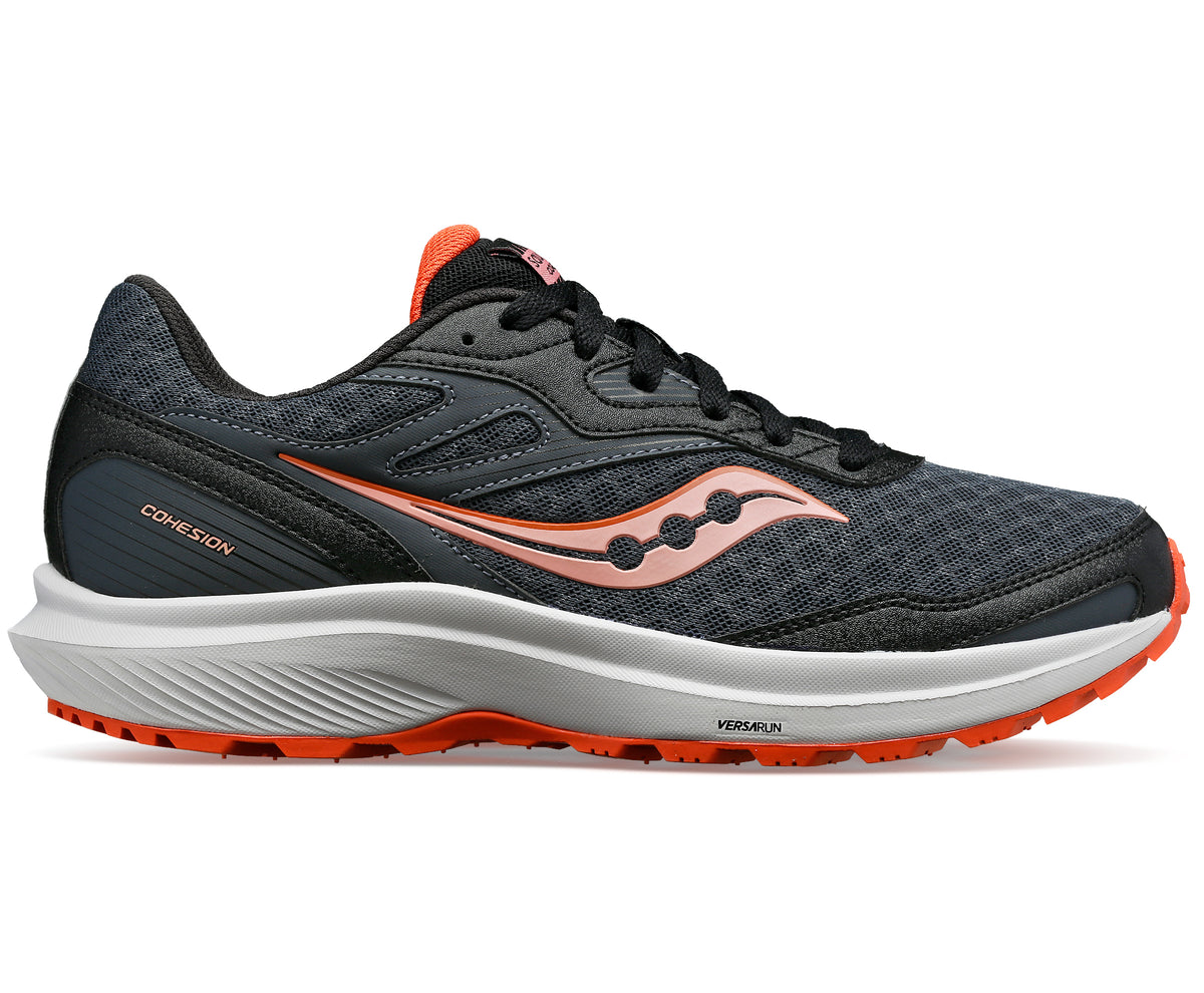 Side view of a gray running shoe with a coral logo and accents on a white and coral sole, with the word "COHESION" printed on the heel.