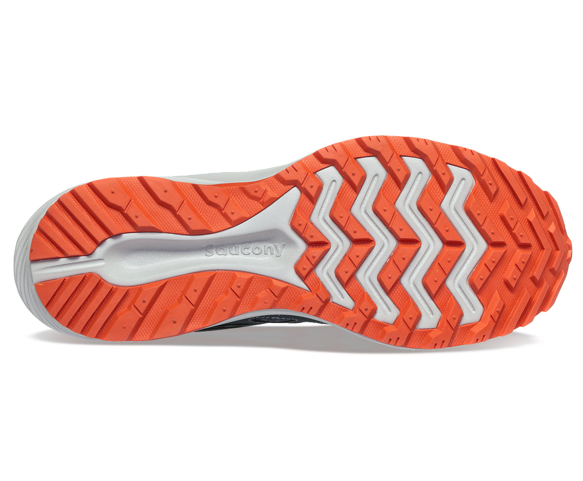 Bottom view of a shoe with an orange outsole featuring a geometric zig zag tread pattern.