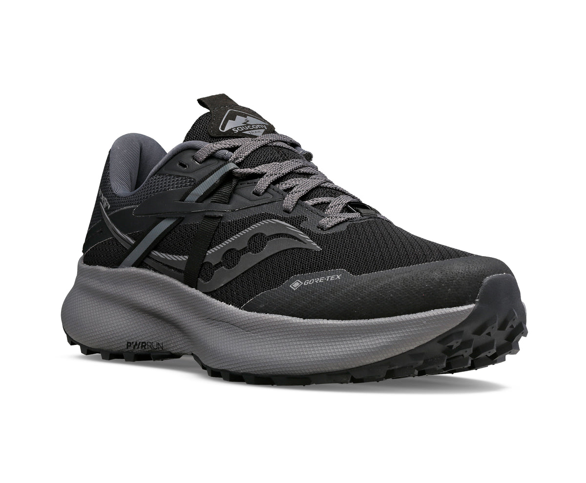Black and grey running shoe with lug sole and Gore-Tex marking.