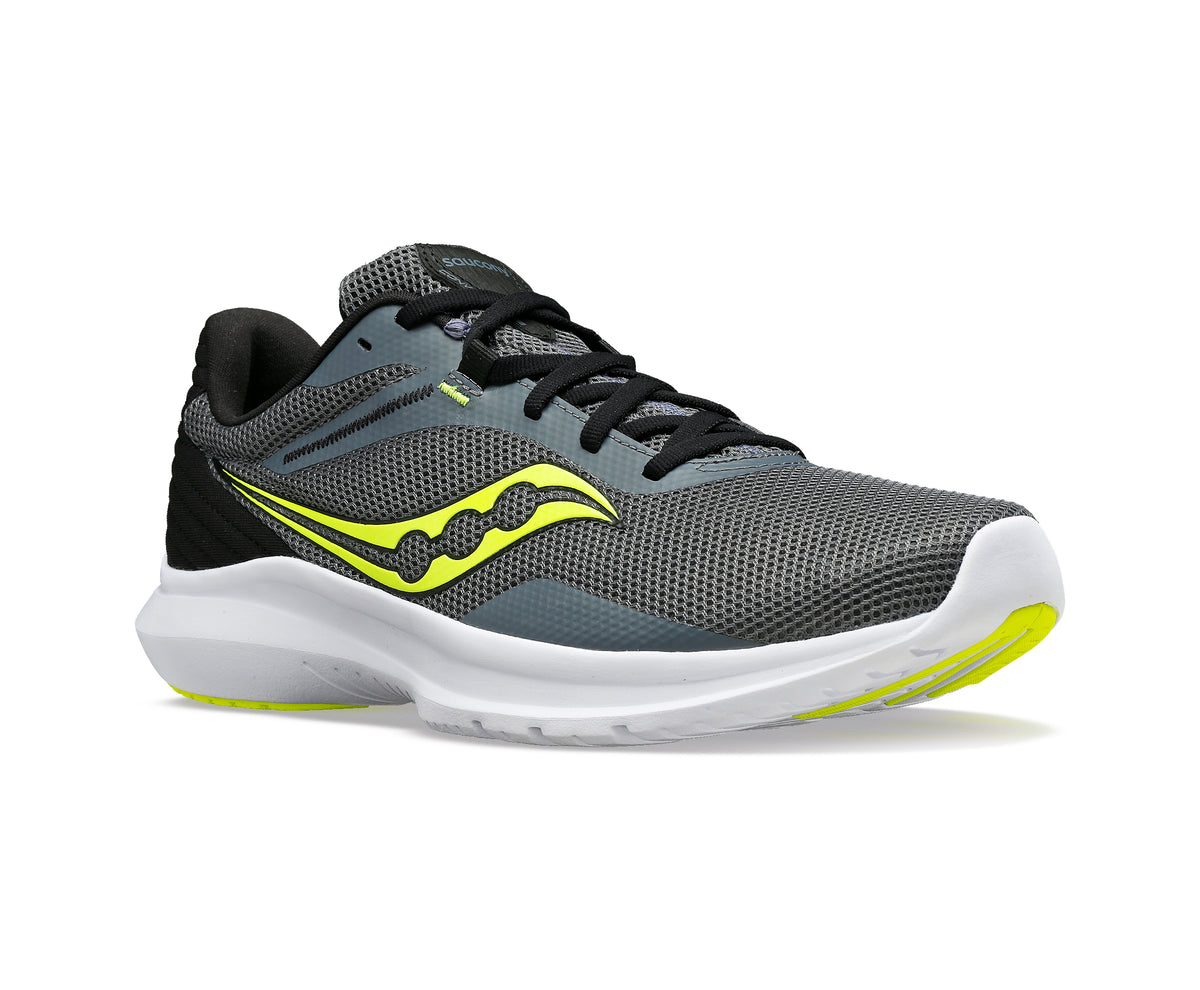 Gray athletic shoe with yellow logo, black laces, white sole, and black heel.