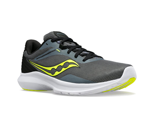 Gray athletic shoe with yellow logo, black laces, white sole, and black heel.