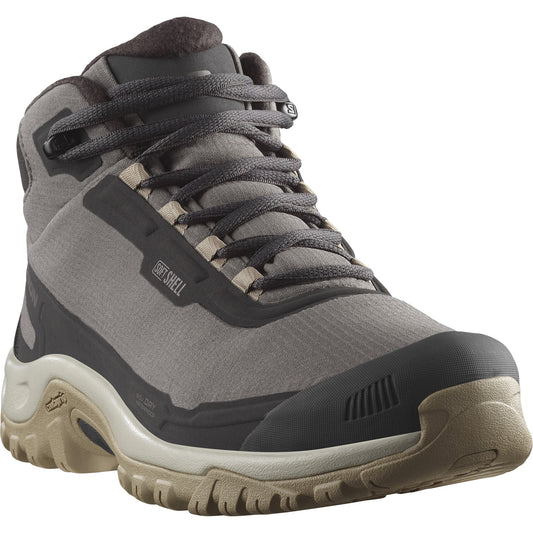 Gray high top hiking boot with black rubber toe and laces, a beige sole, and the words "SOFT SHELL" on the side.