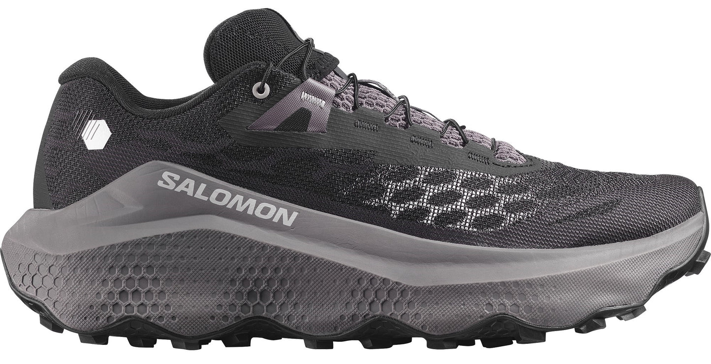 Trail running shoe with a black mesh upper, a grey honeycomb pattern on the midsole and toebox, visible SALOMON text on the side, and black laces.