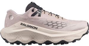 Tan colored athletic shoe with black laces and white midsole with visible logo.