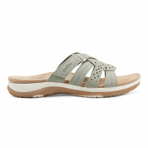 Light green sandal with criss-cross straps and perforated design, resting on a light sole and brown tread.